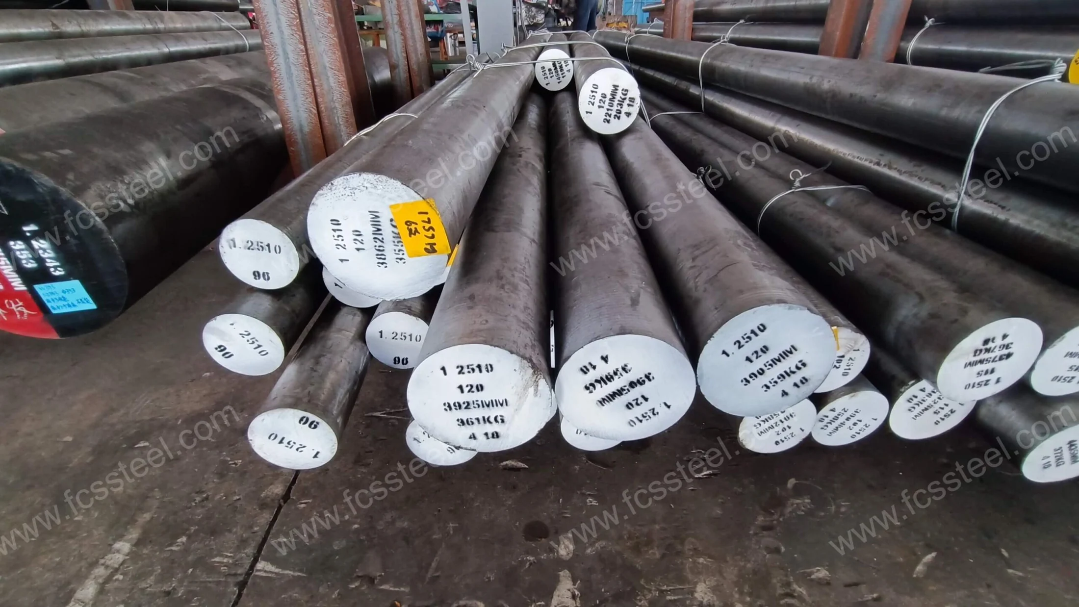 D2 tool steel supplier stock of several cold work grades, bar ends marked and racked side by side